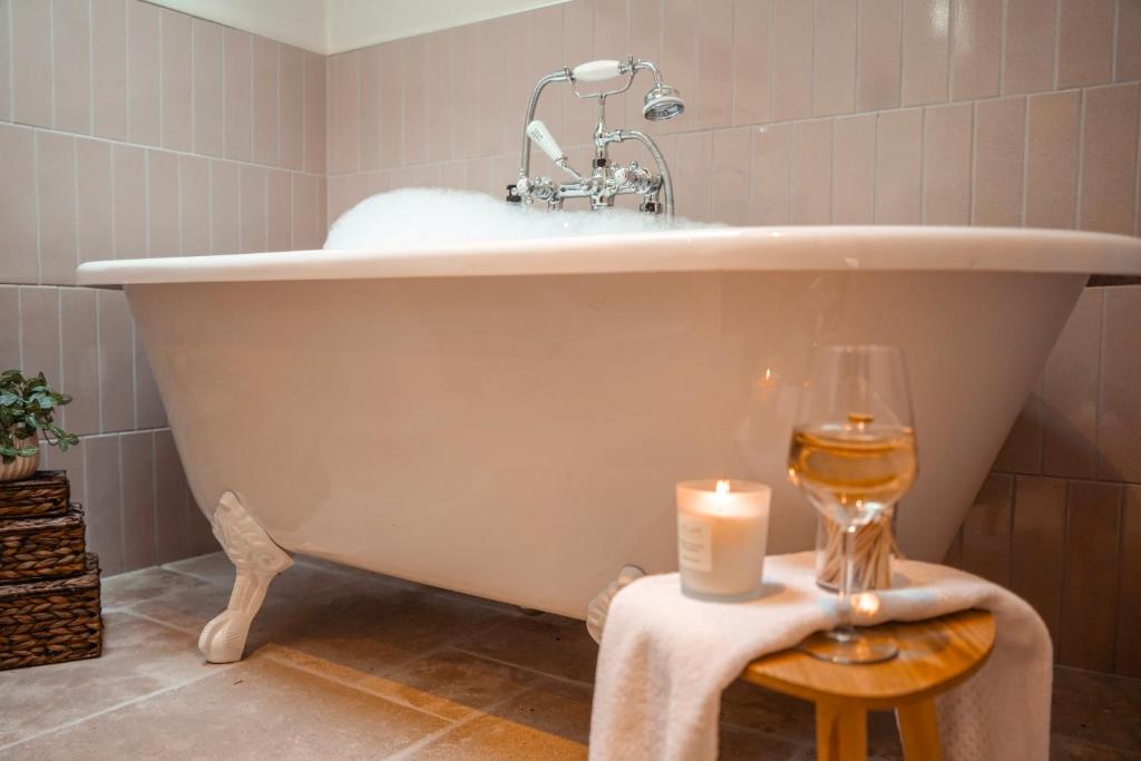 Roll-top bath with candles and a glass of wine